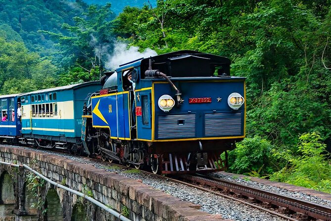 Historic Ooty toy train crossing curved mountain bridge